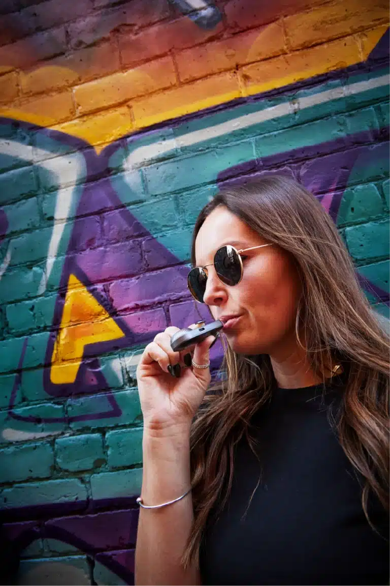 Woman using Grab N Dab in front of graffiti